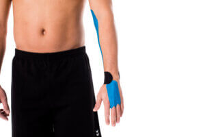 Physiotherapist applies medical tape to person's arm to treat carpal tunnel syndrome